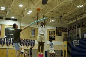 Bobby Perez contesting a shot with a pool noodle during a lesson