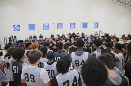 Bobby Perez addressing a full gym of players at a camp