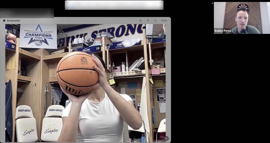 Live call screen share: a college player's set point frozen on screen in her team locker room while the coach breaks it down