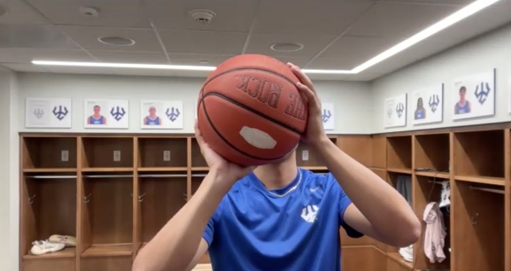 A Washington and Lee player holding the ball at his set point on a live call from his team locker room